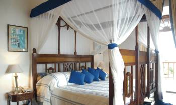 a bedroom with a bed and a chair in a room