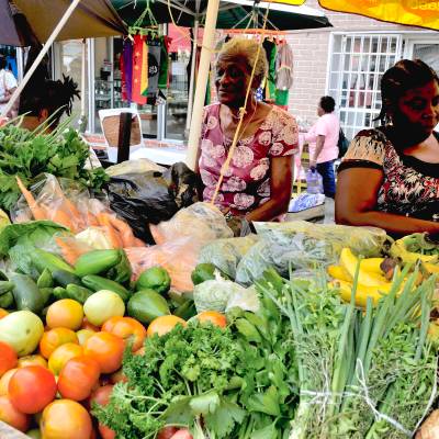 a group of people sitting at a fruit stand