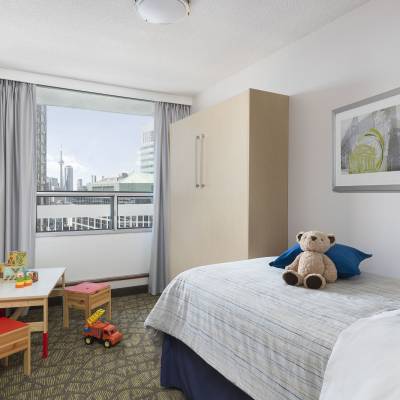 a bedroom with a stuffed animal sitting on a bed