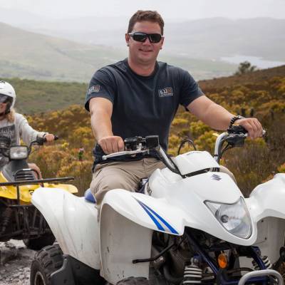 a man riding a motorcycle with a mountain in the background