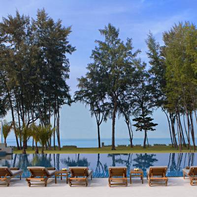 a row of wooden benches sitting on top of a sandy beach