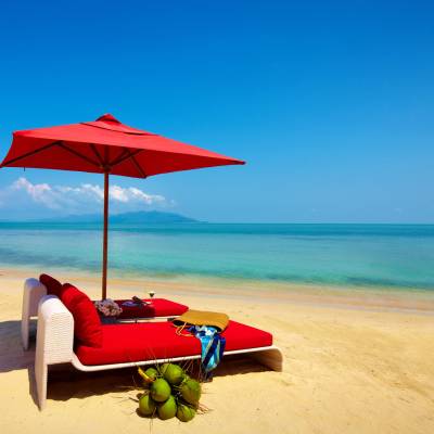 a red umbrella sitting on top of a beach