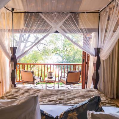 a bedroom with a bed and a chair in a room