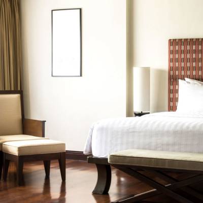 a bedroom with a bed and a chair in a room