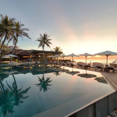 a group of palm trees next to a pool of water