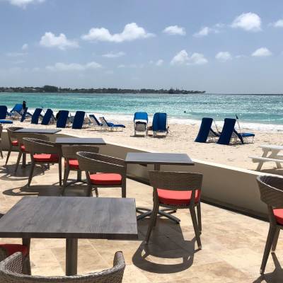a group of lawn chairs sitting on top of a sandy beach