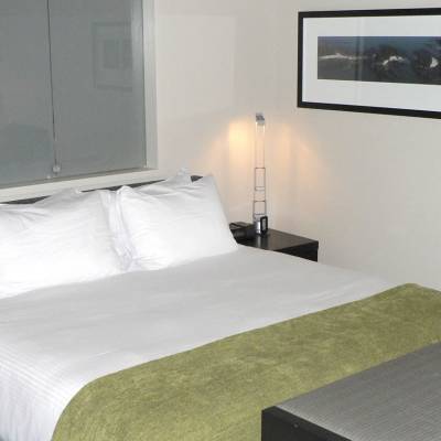 a bedroom with a bed and desk in a hotel room