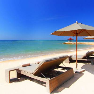 a couple of lawn chairs sitting on top of a beach