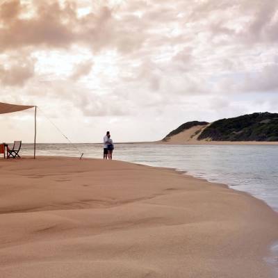 a sandy beach next to a body of water