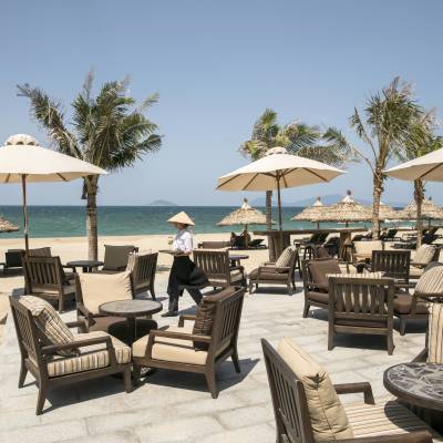 a group of lawn chairs sitting on top of a sandy beach