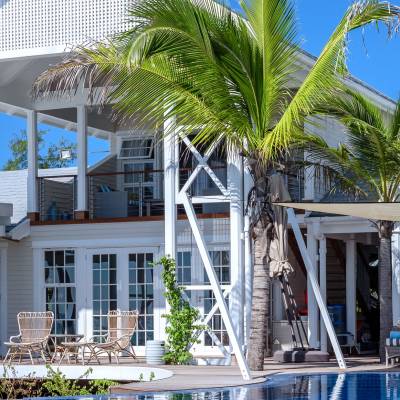 a large white building with palm trees in front of a house