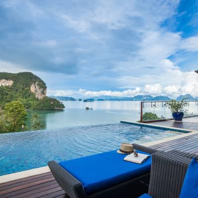 a blue chair next to a body of water
