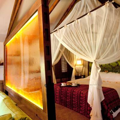 a bedroom with a bed and a chair in a room