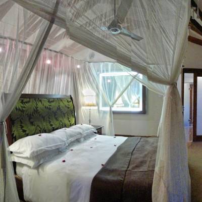 a bedroom with a bed and a chair in a room