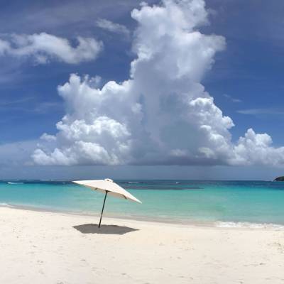a blue umbrella sitting on top of a sandy beach