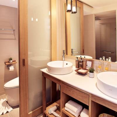 a white sink sitting under a mirror