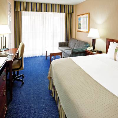 a bedroom with a bed and desk in a room