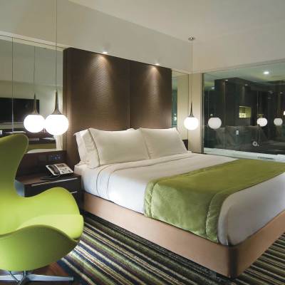 a bedroom with a bed and a chair in a room