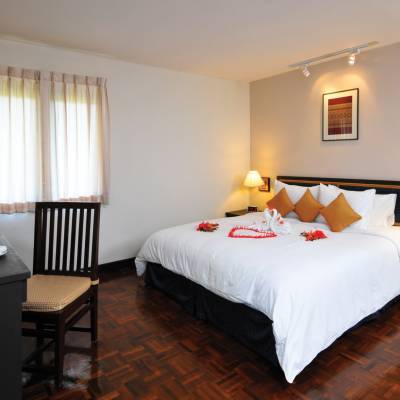 a bedroom with a bed and desk in a hotel room