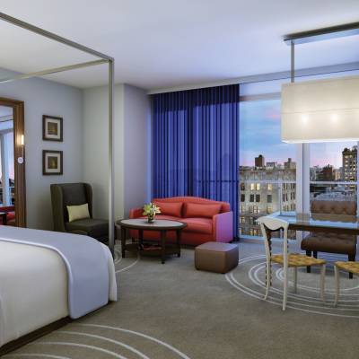 a bedroom with a bed and desk in a hotel room