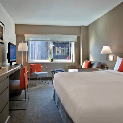 a bedroom with a bed and desk in a room
