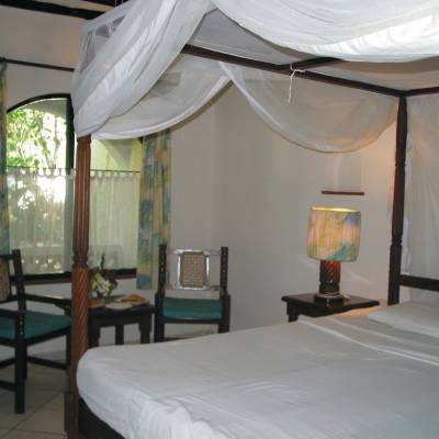 a bedroom with a bed and a chair in a room