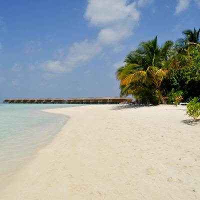 a sandy beach next to a body of water