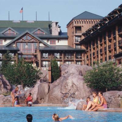 a group of people in a swimming pool with Disney's Wilderness Lodge in the background