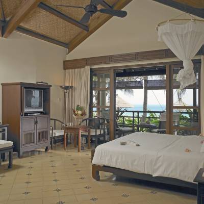 a bedroom with a bed and a chair in a room