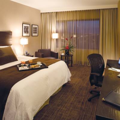 a bedroom with a bed and desk in a hotel room