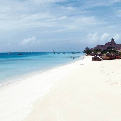 a sandy beach next to a body of water