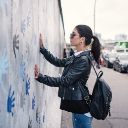 Enchanting Travels Germany Tours Young woman in front of Berlin Wall - German History