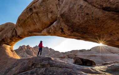 Nature reserve Spitzkoppe in Namibia. Picturesque stone arches are painted by iron oxides in red-orange color