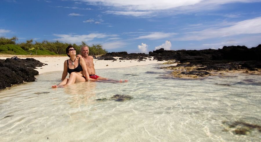 Enchanting Travels Mauritius tours couple is sitting together on a white sand beach