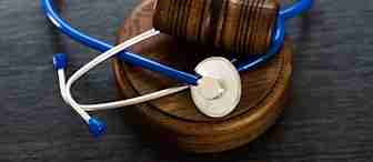 A wooden judge’s gavel resting on a circular sound block with a blue stethoscope draped around it, symbolizing the intersection of law and healthcare.