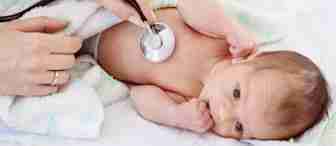 A baby lies on a soft blanket while a healthcare professional checks the baby's chest with a stethoscope. The baby is looking up, partially covered with a light blanket adorned with green stars.