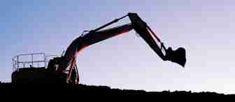 Silhouetted against a fading sunset sky, an excavator with a bucket arm extends its boom above a mound of dirt. The scene conveys a tranquil yet industrious atmosphere.