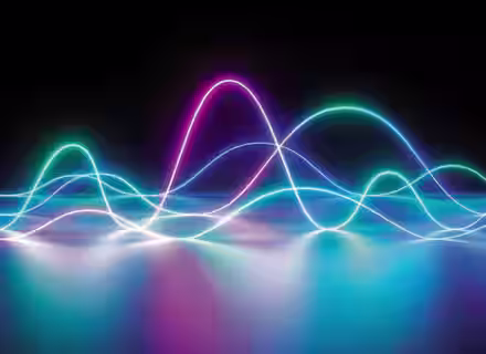 A colorful, surreal light wave pattern is displayed against a dark background. The waves emit a glowing effect, with hues of blue, pink, and green. They create an abstract landscape that reflects softly on a smooth, reflective surface.
