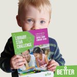 A young blonde haired boy holds up the library star challenge booklet