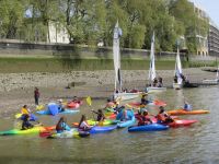 children in kayaks on the river thames