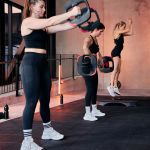 image shows people lifiting weights in a workout class image shows people lifiting weights in a workout class