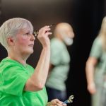 Woman playing darts in green tshirt