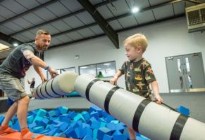 Father and son playing in a trampoline park