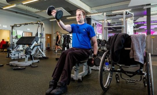 male member in the gym with a wheelchair