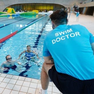Swim doctor teacher, giving instruction to person in water