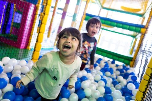 This image shows two children having fun in a ball pit