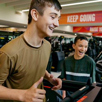 Two teenage boys working out the gym together Two teenage boys working out the gym together