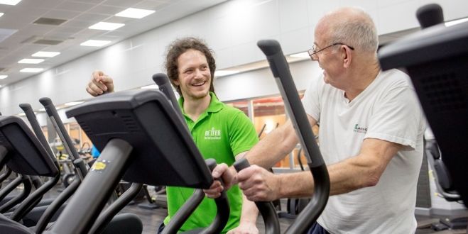 instructor with older male in the gym