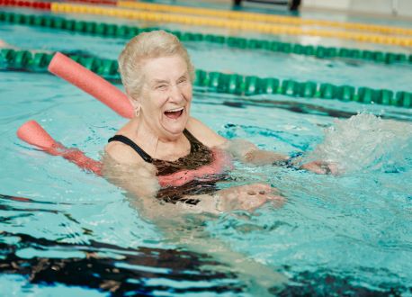 senior female enjoying a swim with a big smile