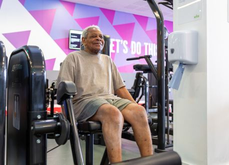 senior male using a resistance machine with a big smile